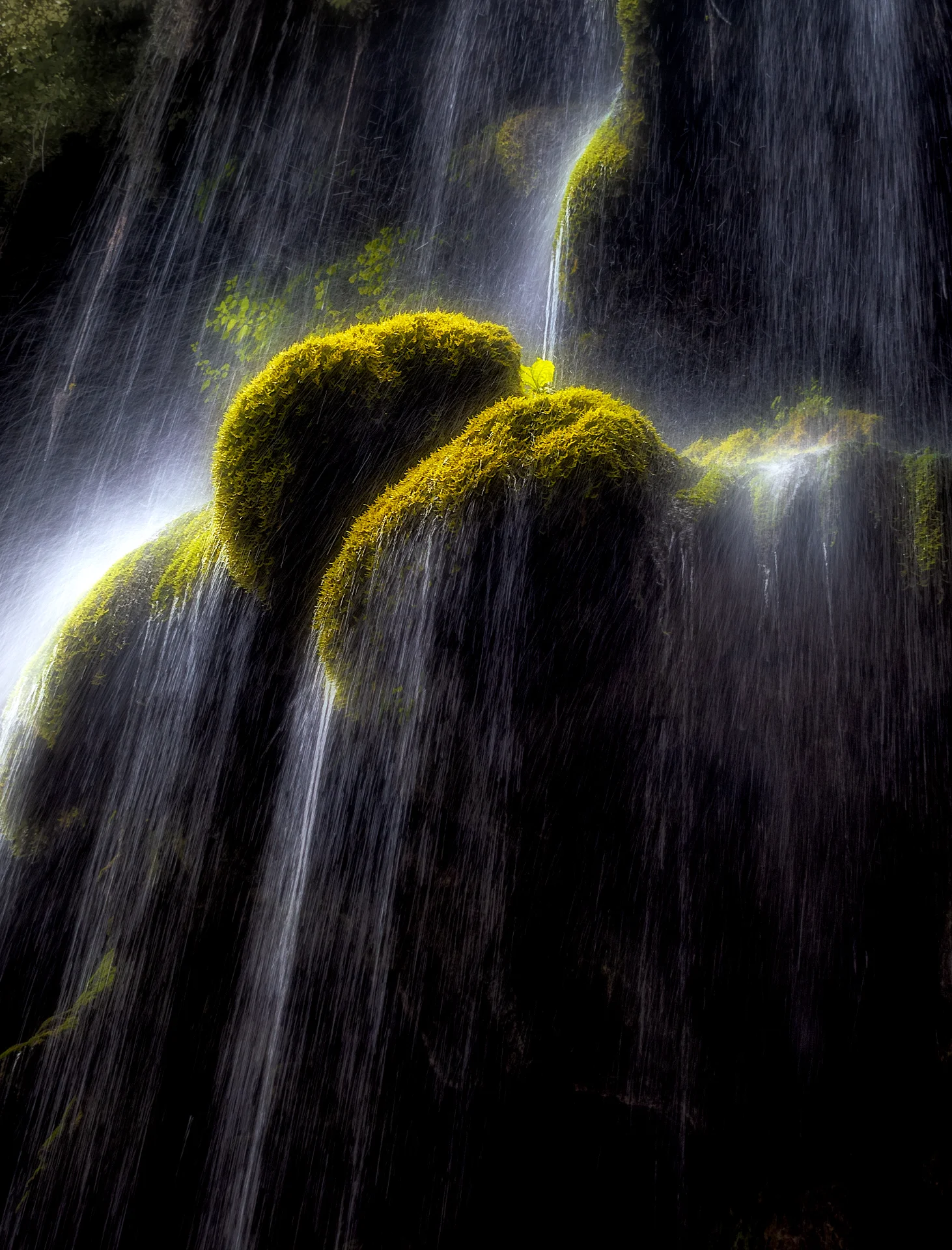 Close-up view of water cascading over vibrant green moss-covered rocks at Behesht Baran Waterfall in Golestan Province. Photograph by Mohammad Ataei.
